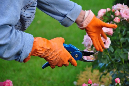Gardeners at work beside labeled recycling bays in Earls Court hub
